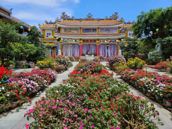 Temple with purple doors and flower beds in front