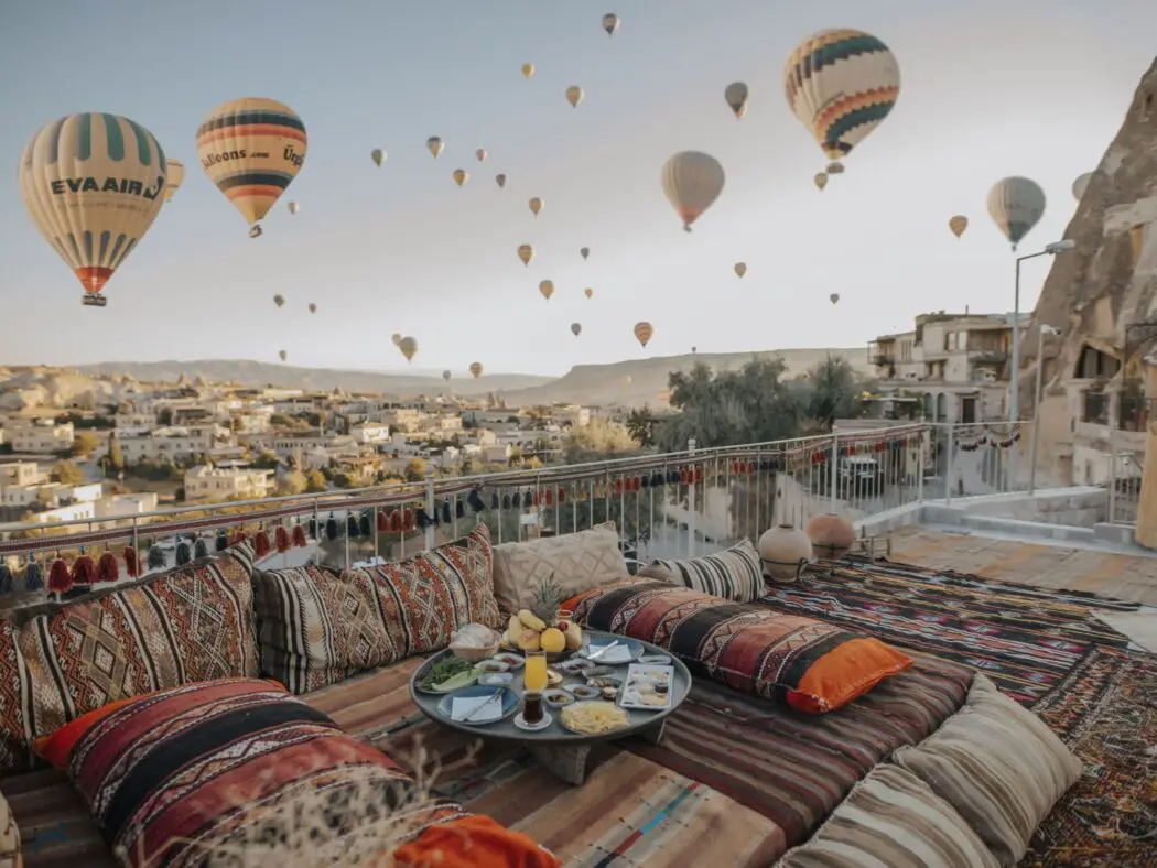 Terrace with cushions on and hot air balloons floating in the sky above