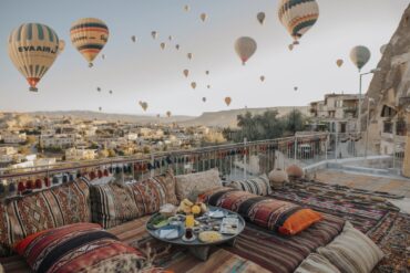 Terrace with cushions on and hot air balloons floating in the sky above