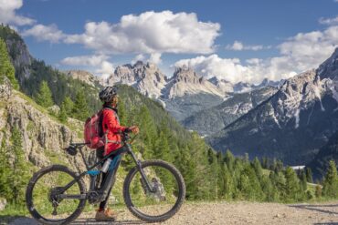 Woman standing with electric bike in the mountains