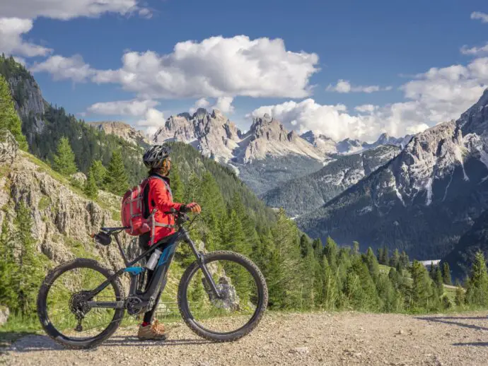 Woman standing with electric bike in the mountains