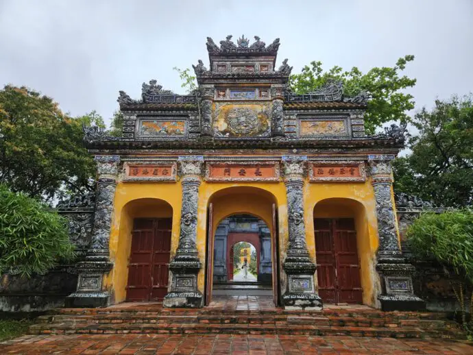 Old stone gate with 3 archways and yellow decoration