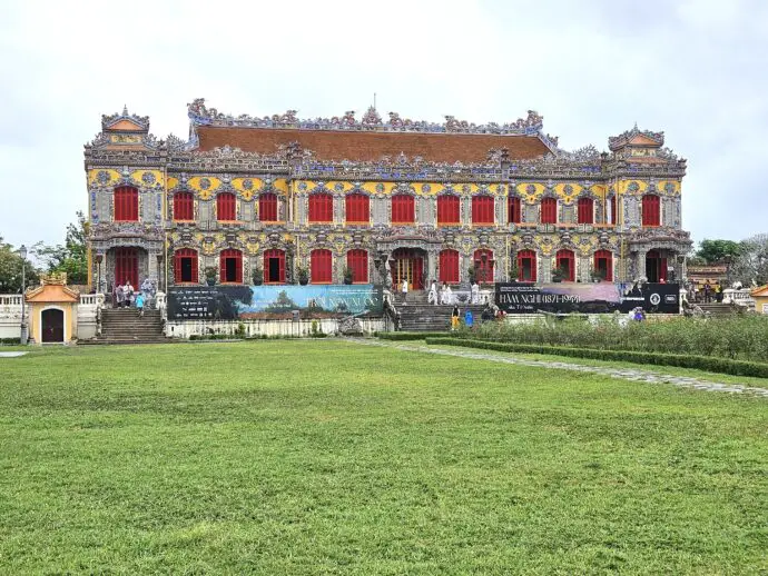 Ornate palace with red window frames in front of a grassy lawn