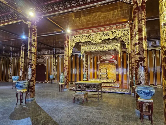 Golden throne in room surrounded by pillars