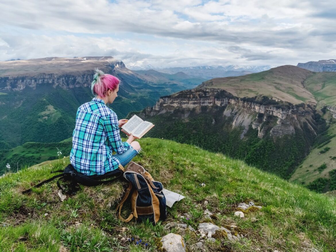 Woman reading on a mountainside