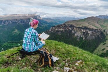 Woman reading on a mountainside
