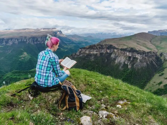 Woman reading on a mountainside