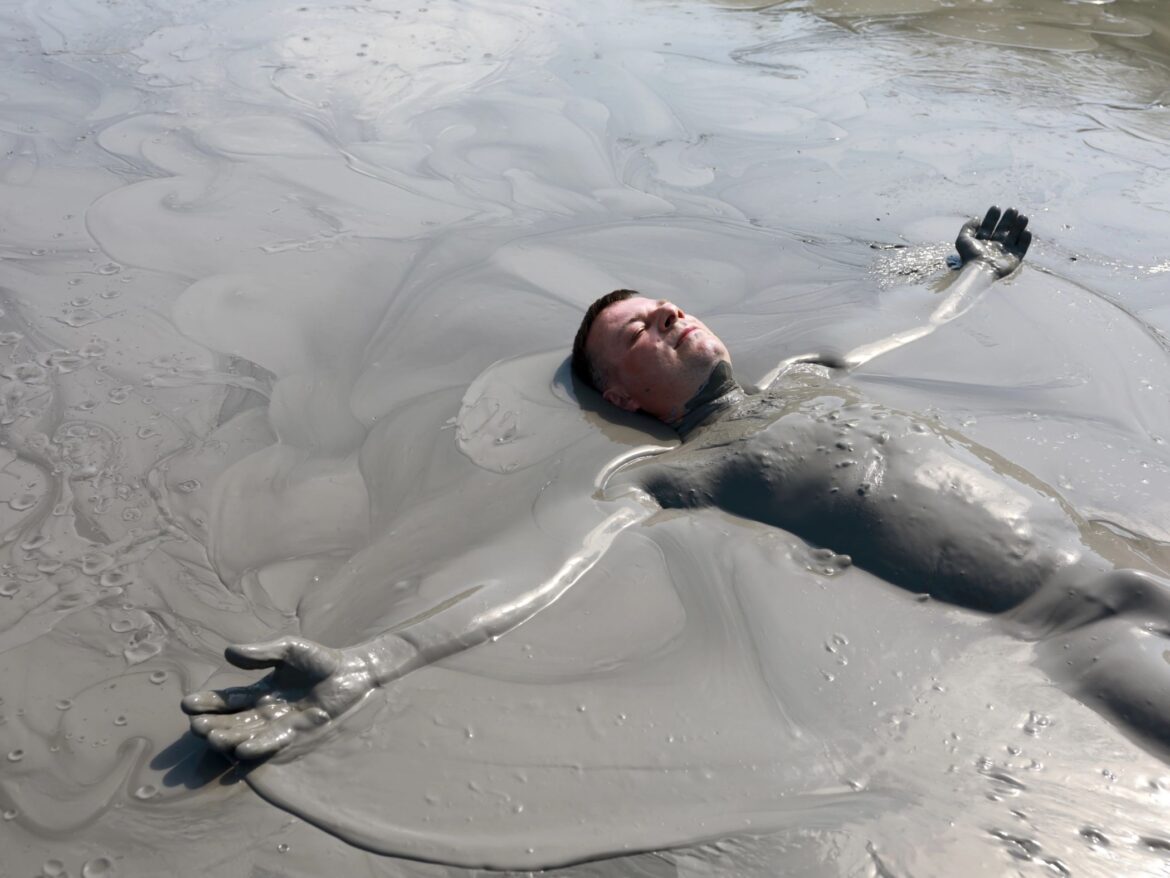 Man lying in a mud bath