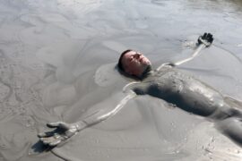 Man lying in a mud bath