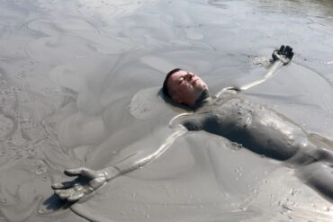Man lying in a mud bath