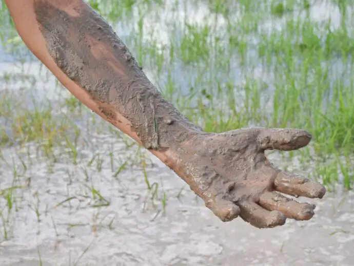 Mans arm covered in mud